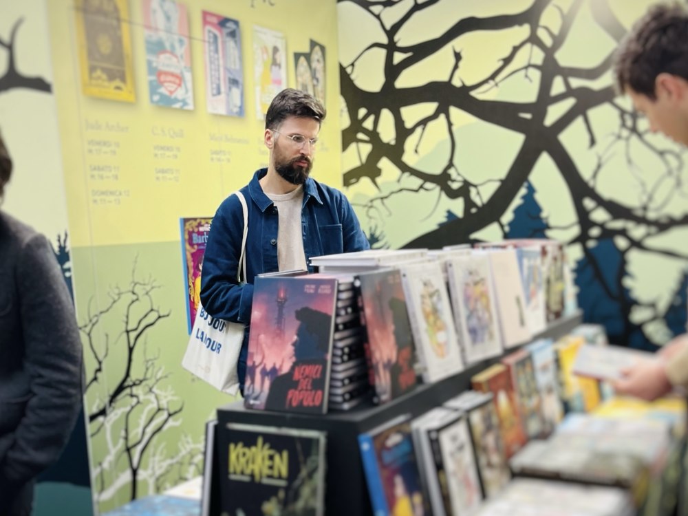Alessandro browsing comics and graphic novels at a book fair